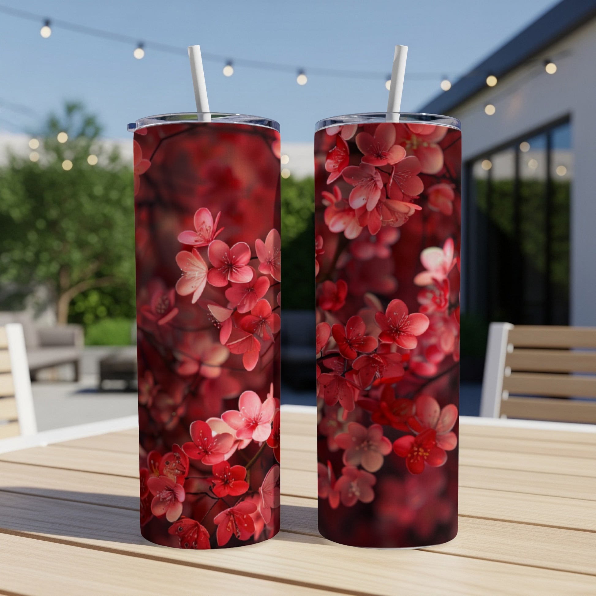 Two tumblers with a red floral pattern on a wooden table.