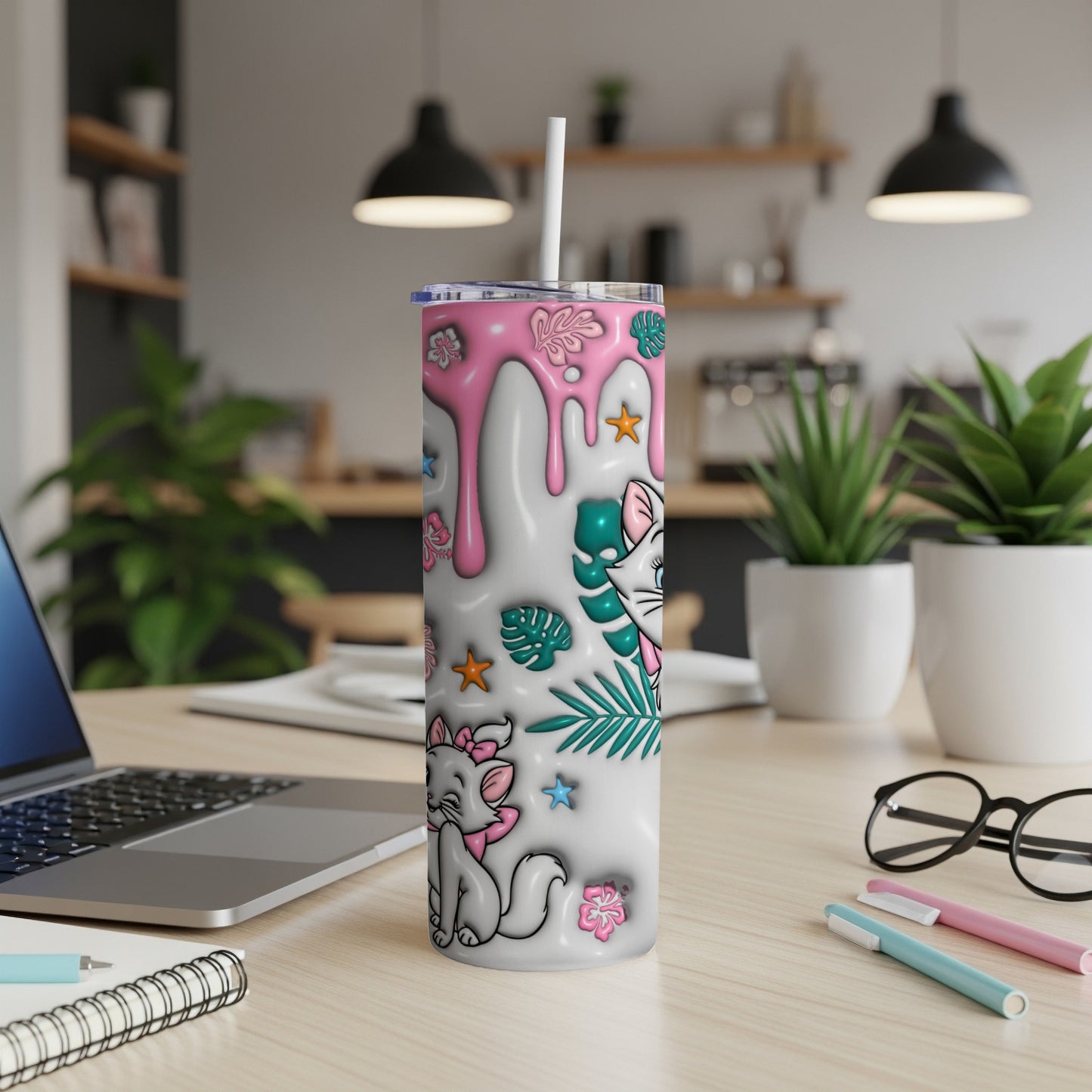 White tumbler with cartoon cat and pink drips, on a desk.