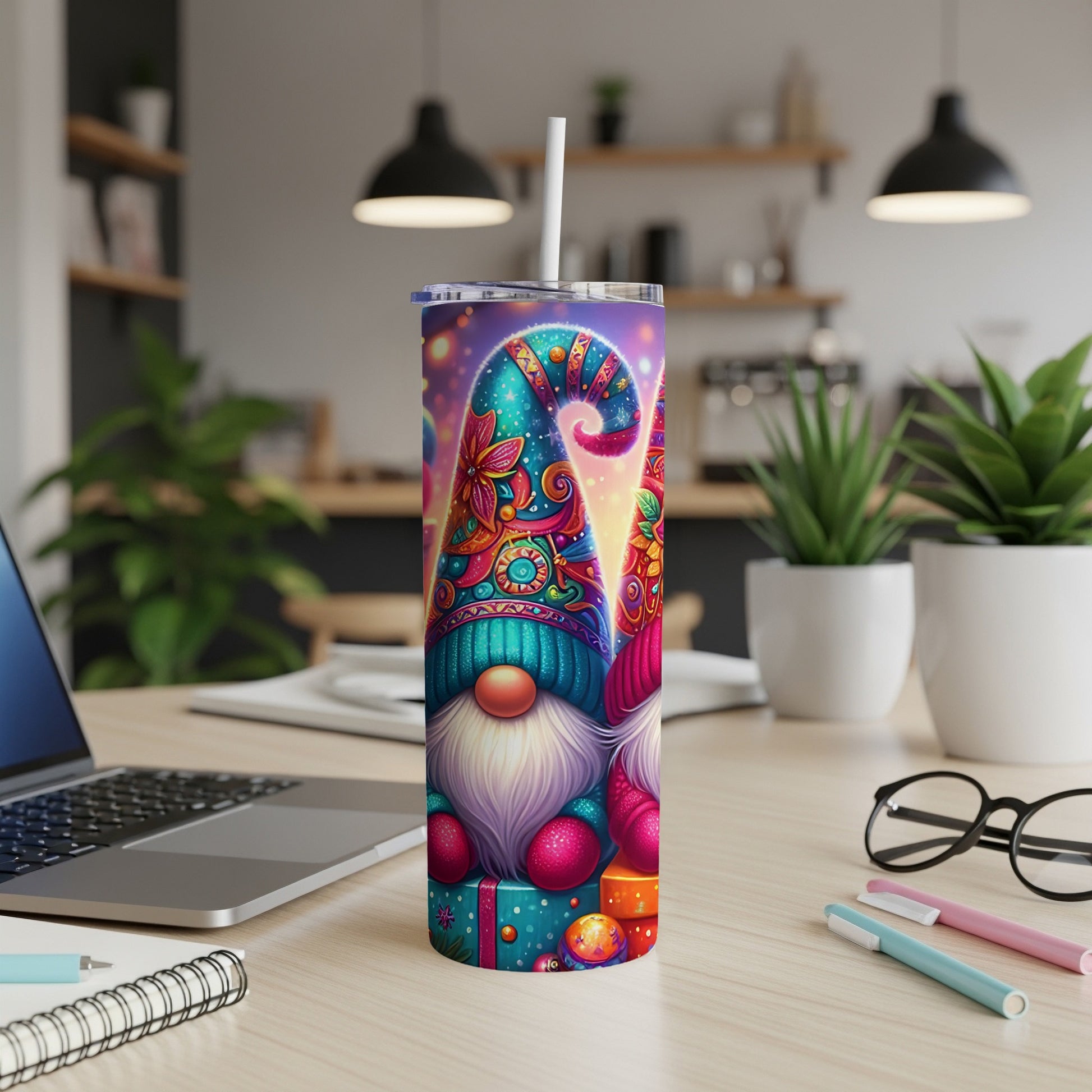 Two gnomes wearing colorful hats with a drink straw in a festive tumbler.