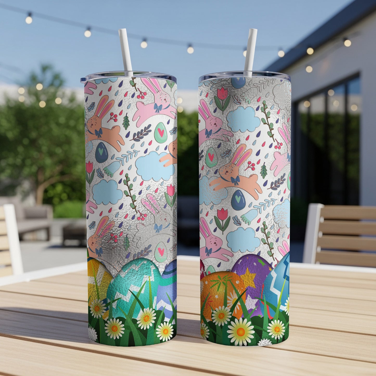 Easter-themed tumblers with rabbits, clouds, and eggs on a table.