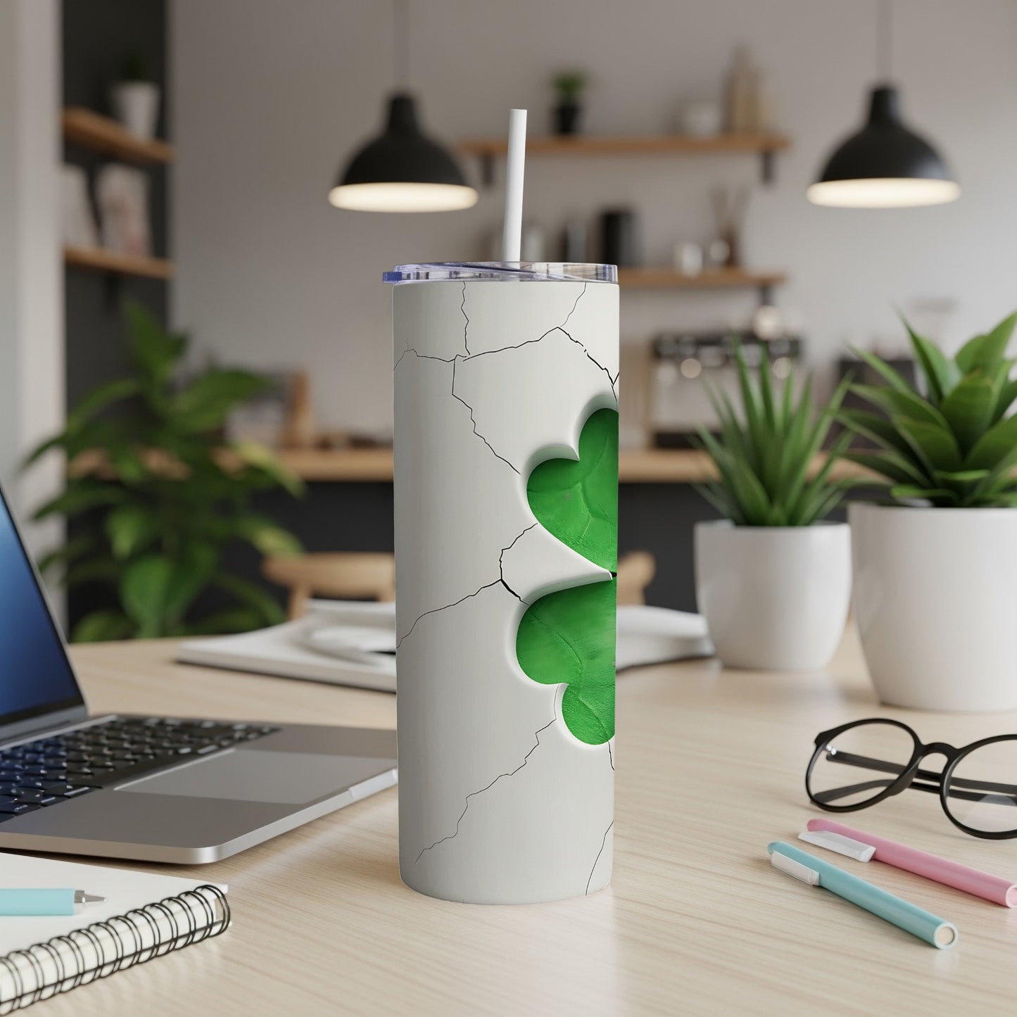 White tumbler with cracked design revealing a green clover design.