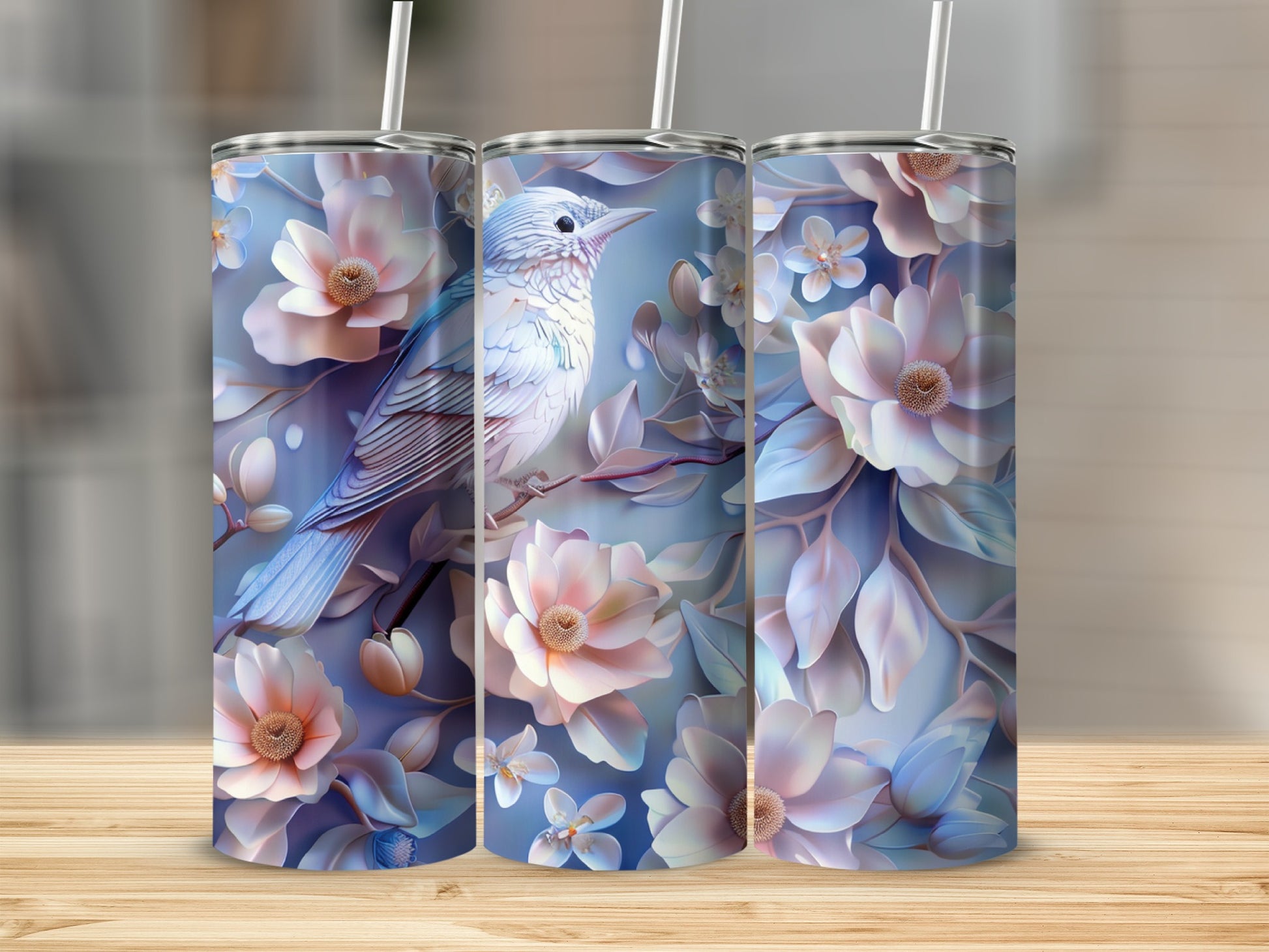 Three tumblers with a bird and floral design on a wooden surface.