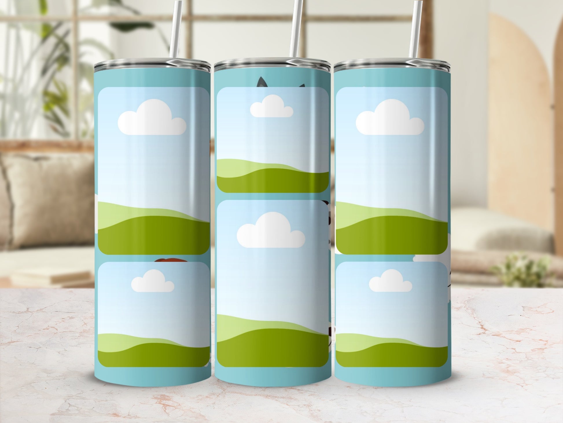 Three tumblers with a cartoon landscape design of green hills and clouds.