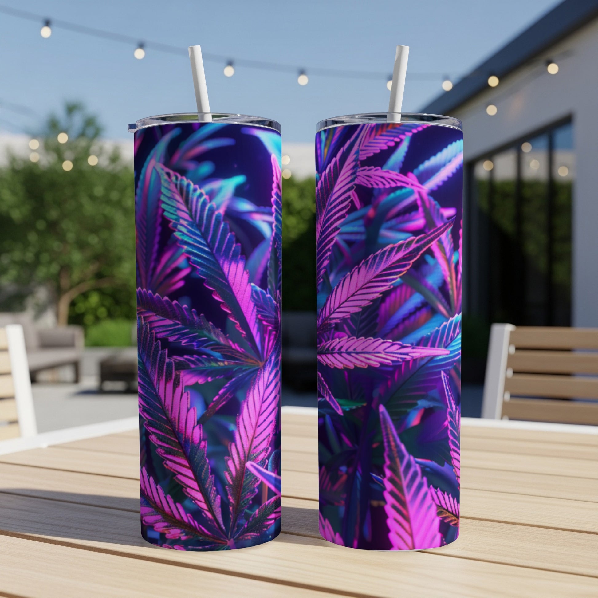 Two tall tumblers with cannabis leaf design, set on an outdoor table.