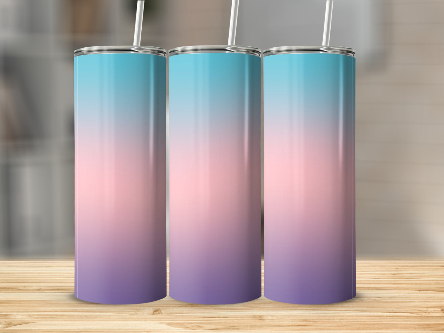 Three gradient tumblers with blue, pink, and purple hues on a wooden surface.