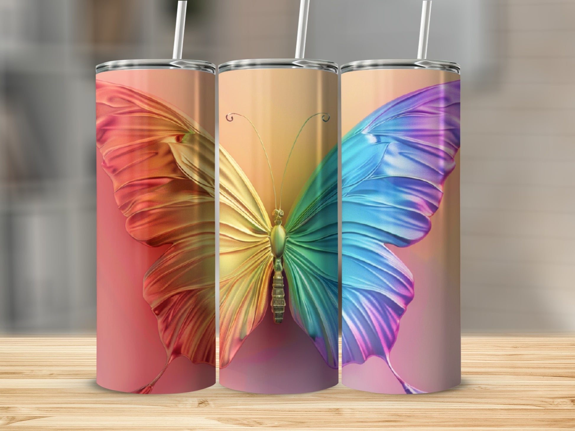 Three tumblers with a colorful butterfly design on a wooden surface.