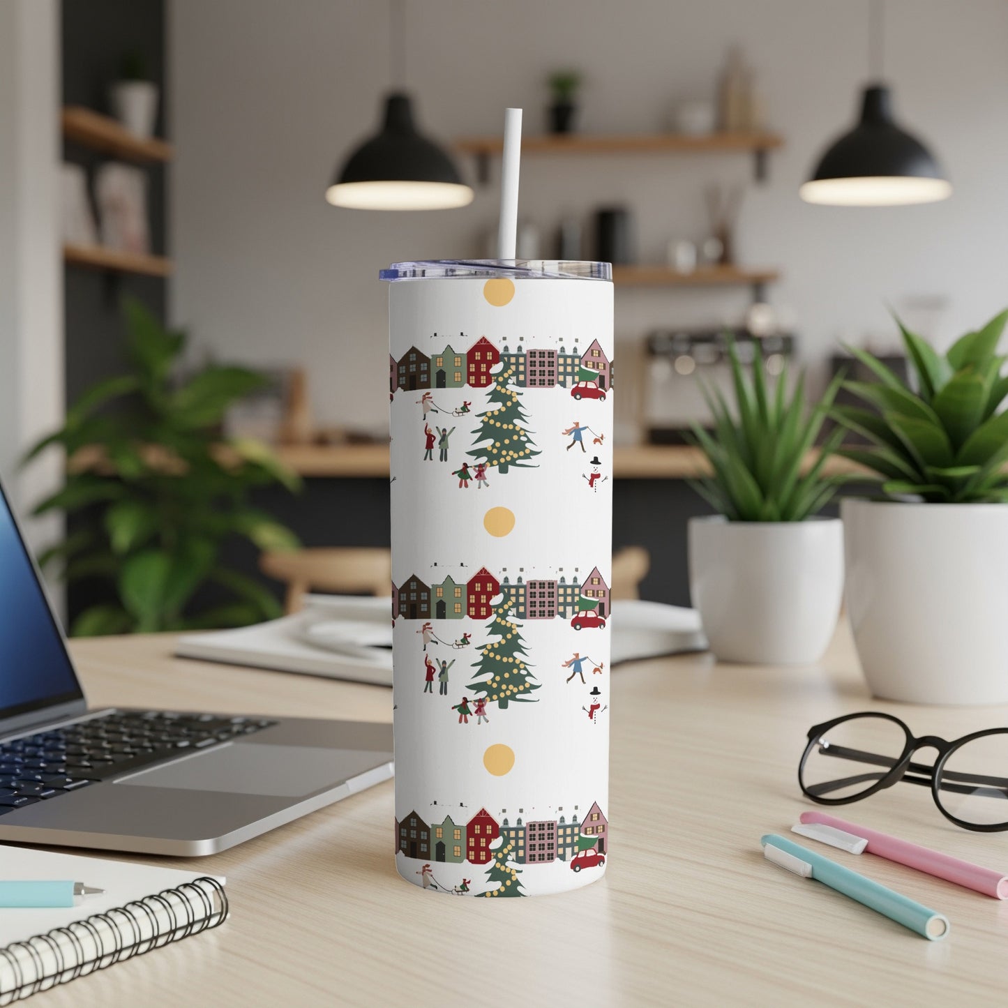 White tumbler with Christmas village and figures pattern, straw inserted.