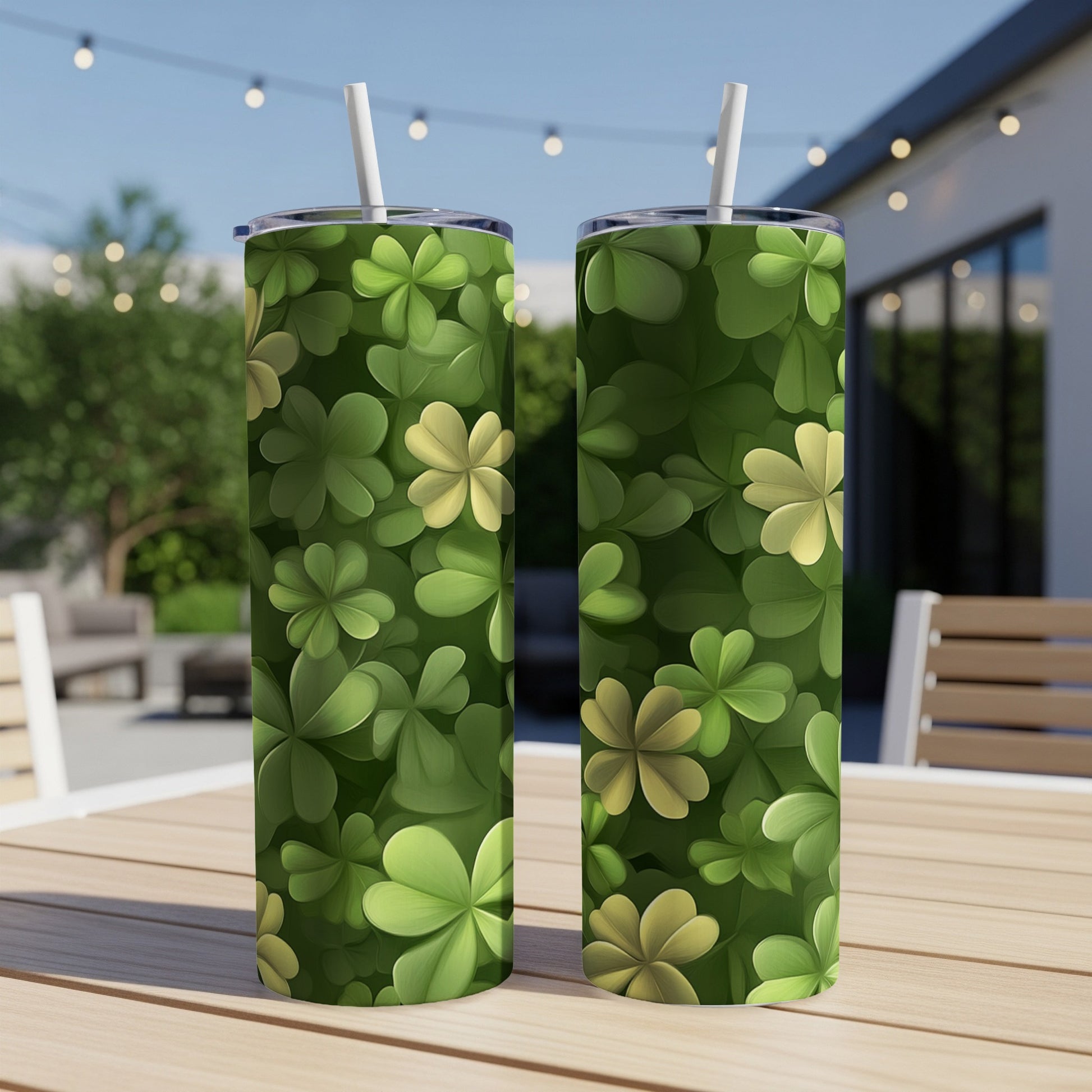 Two green tumblers with clover leaf pattern sit on a table outdoors.
