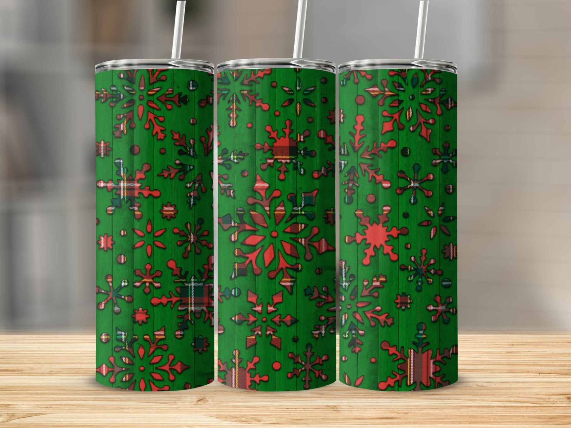 Three green tumblers with red snowflake and plaid pattern.