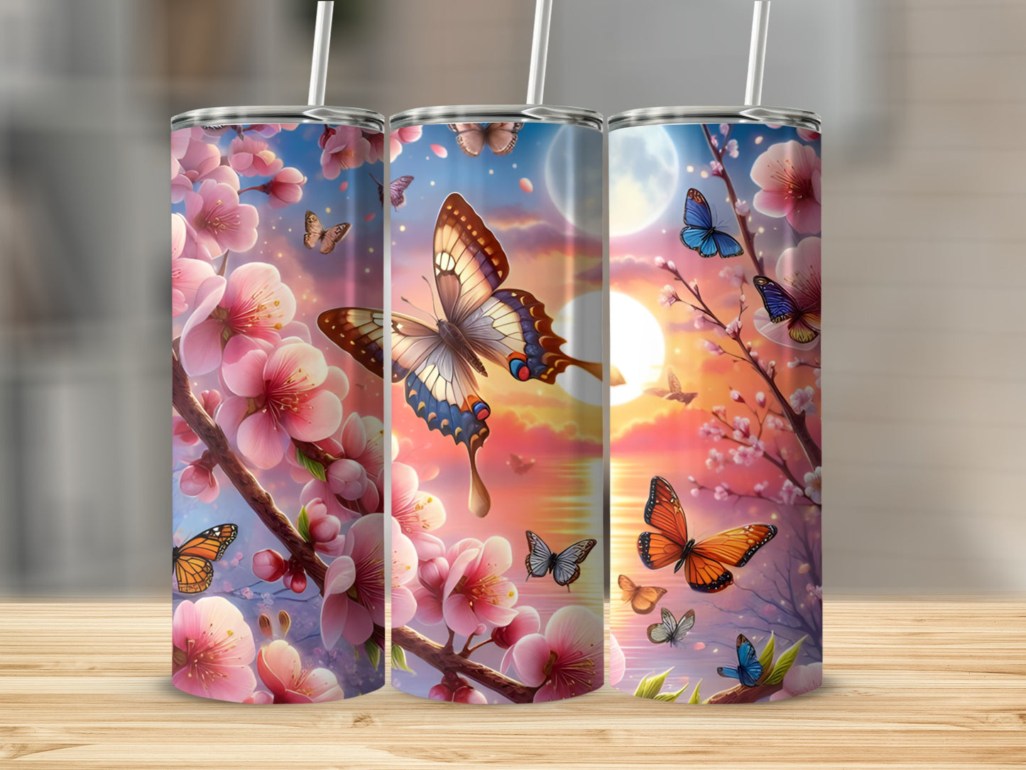 Three tumblers with cherry blossoms and butterflies against a sunset sky.