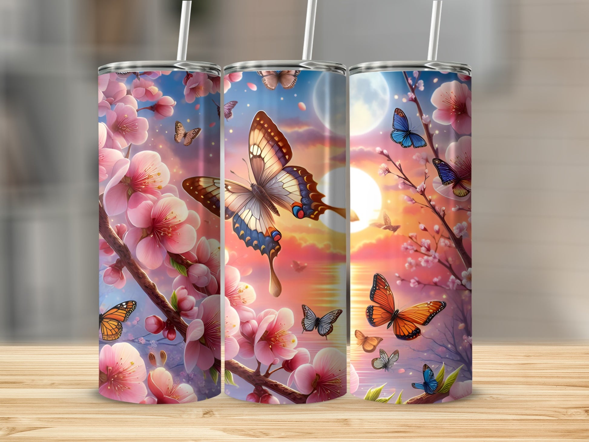 Three tumblers with cherry blossoms and butterflies against a sunset sky.