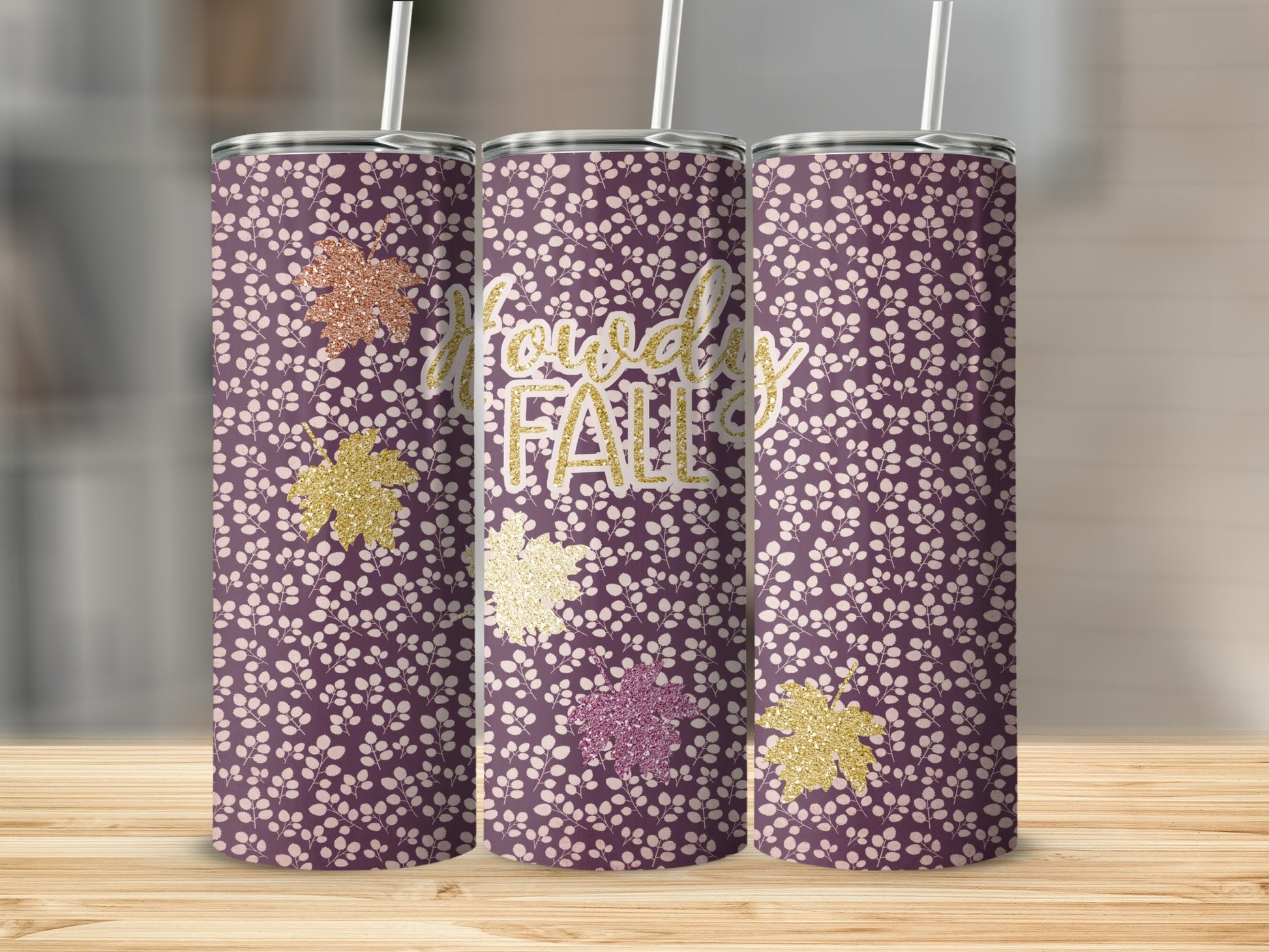 Purple tumbler with white floral pattern and "Howdy Fall" text and glitter leaves.