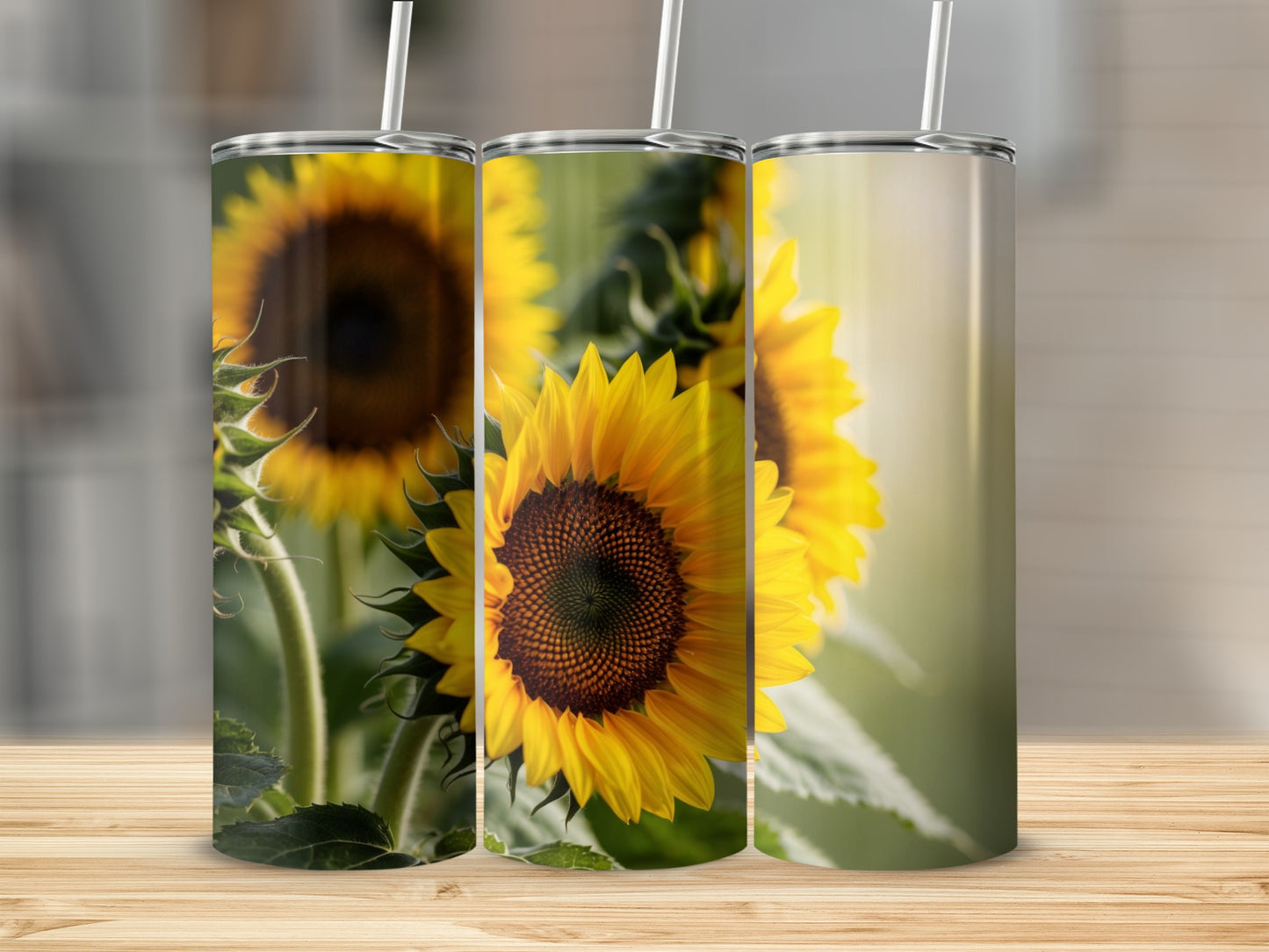 Three tumblers with sunflower designs displayed on a wooden surface.
