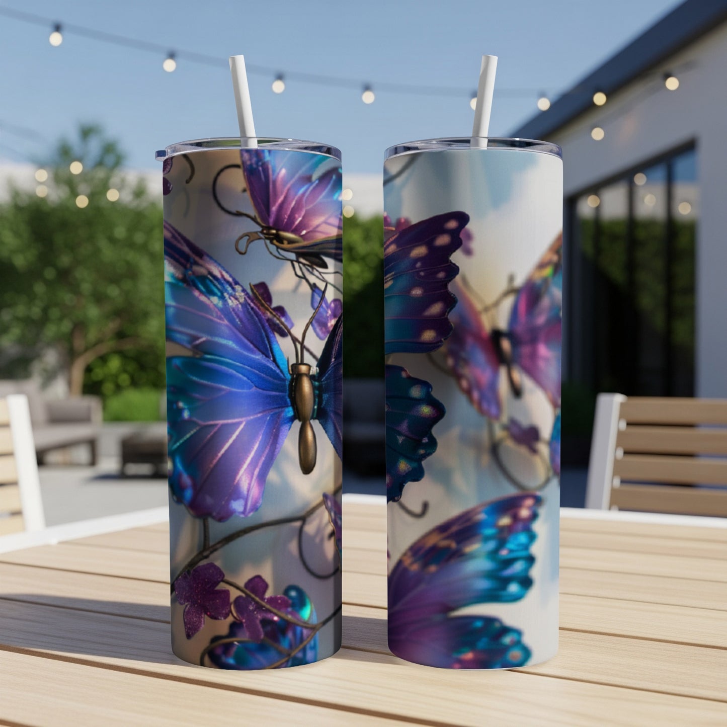 Two tumblers with iridescent purple butterfly designs on a wooden table outdoors.