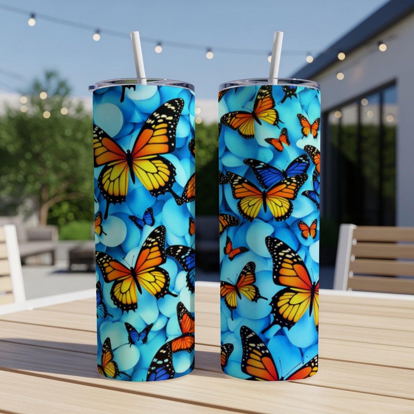 Two tumblers with colorful monarch butterflies on a blue pebble pattern.