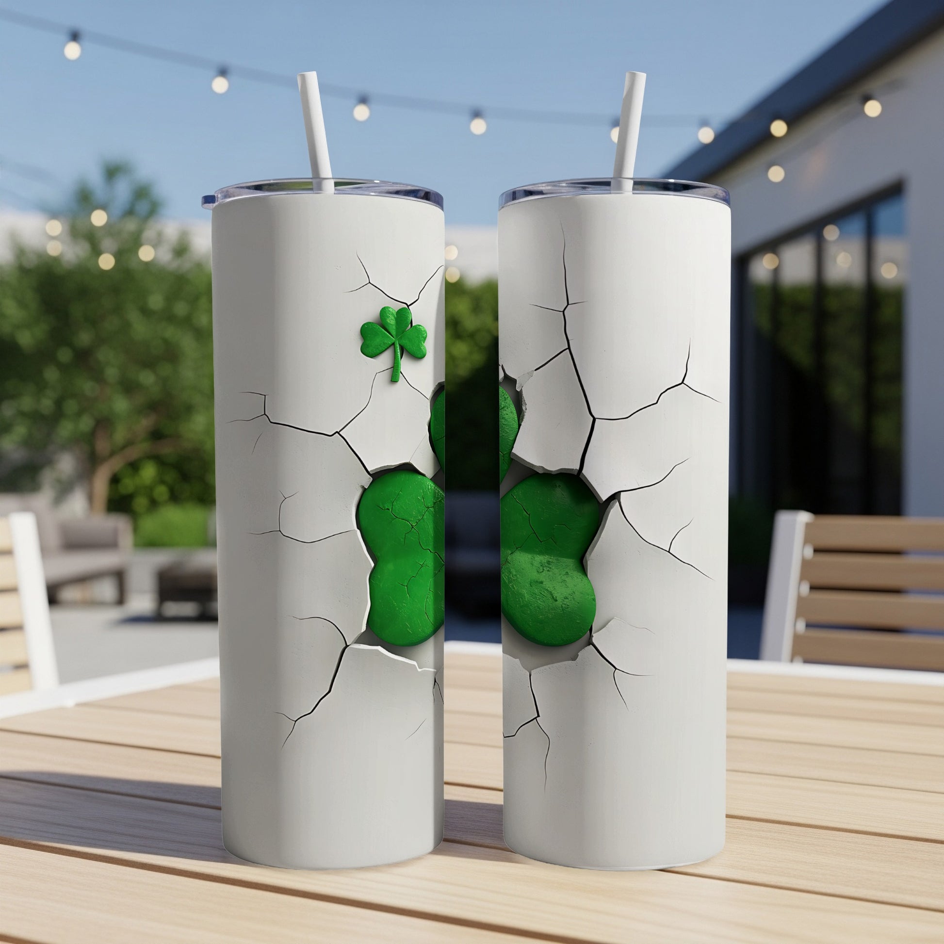 White tumbler with cracked design revealing green shamrock, straw inserted.