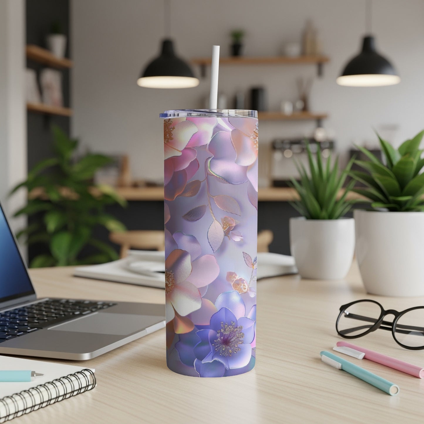 Purple and pink floral insulated tumbler with straw on desk.