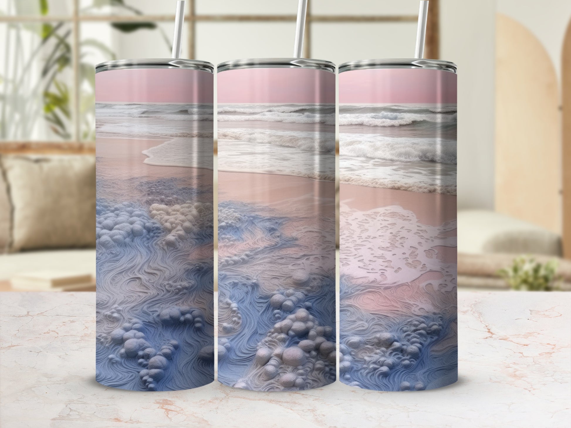 Three tumblers with beach wave and sand print on a marble surface.