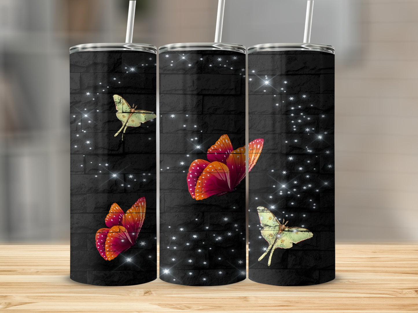 Three tumblers with butterflies and stars on a brick pattern.