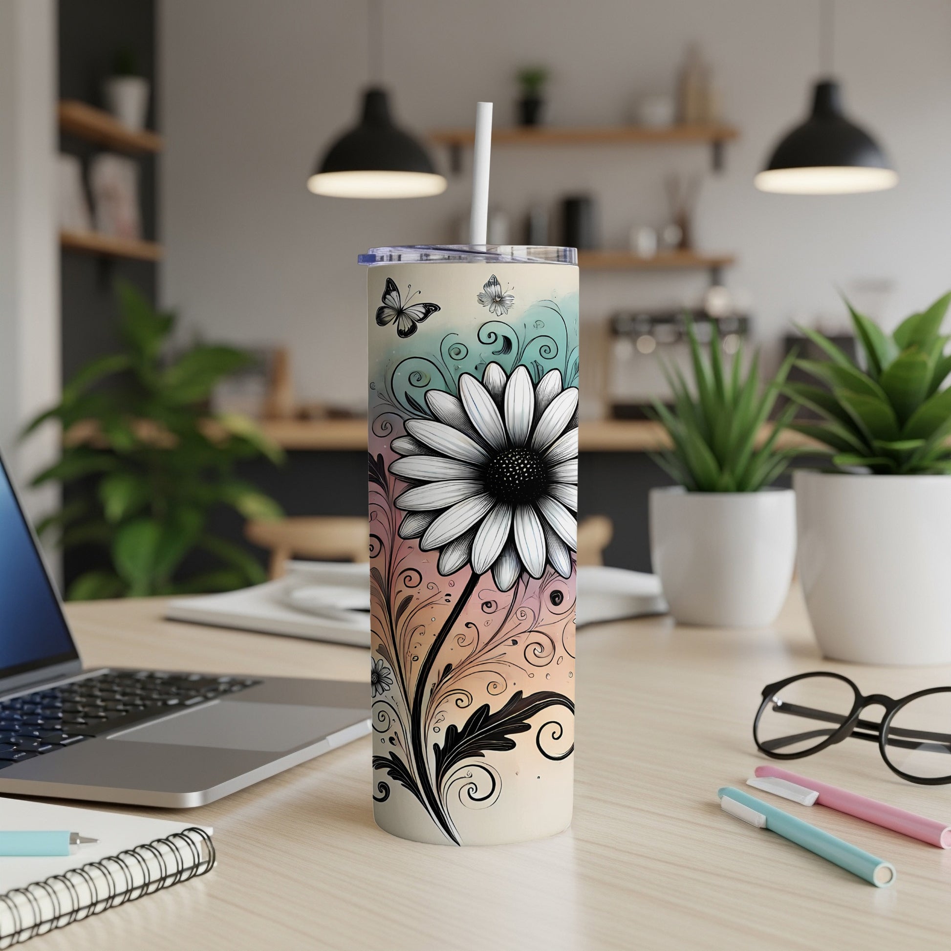 Floral patterned tumbler with butterfly accents, on a desk.