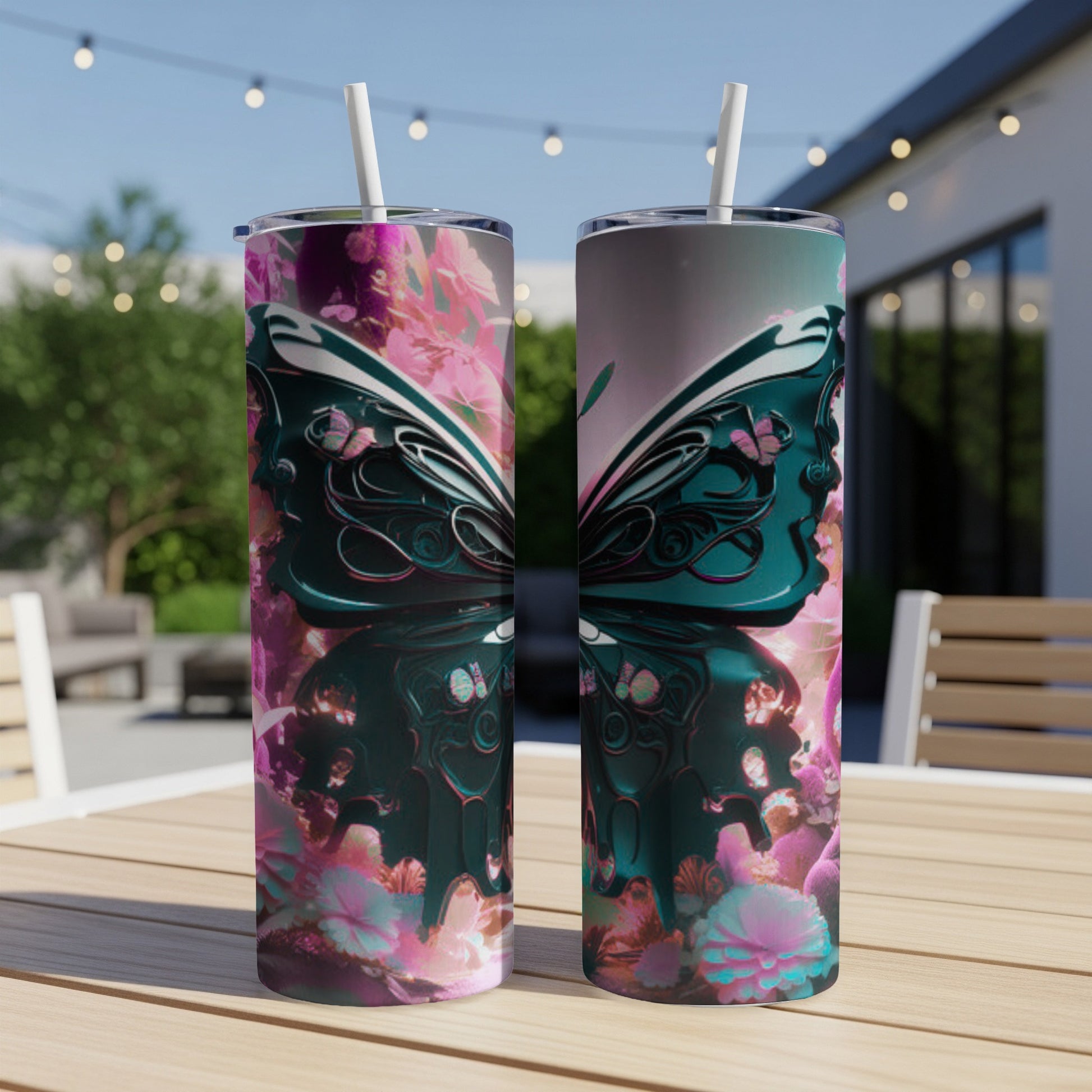 Two tumblers with a teal butterfly and pink floral design on a table.