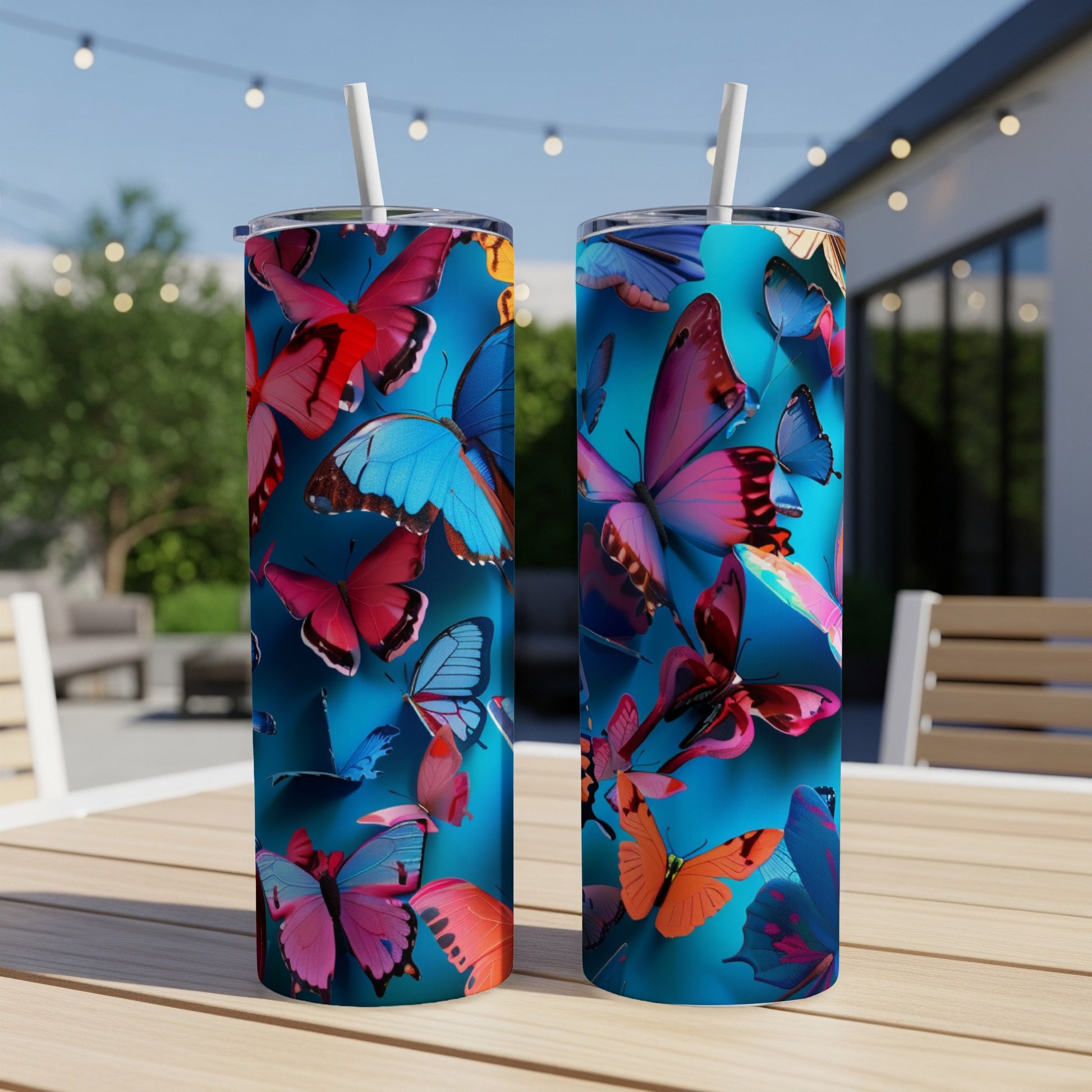 Two tumblers with a vibrant butterfly pattern on a wooden table.