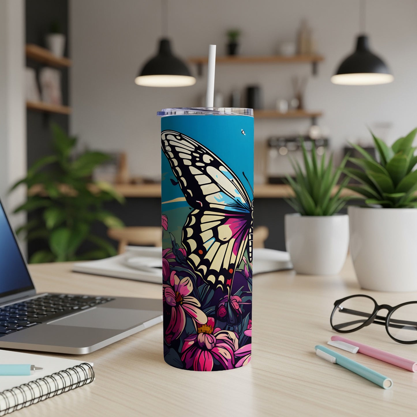 Butterfly and floral design on a blue tumbler with a white straw.