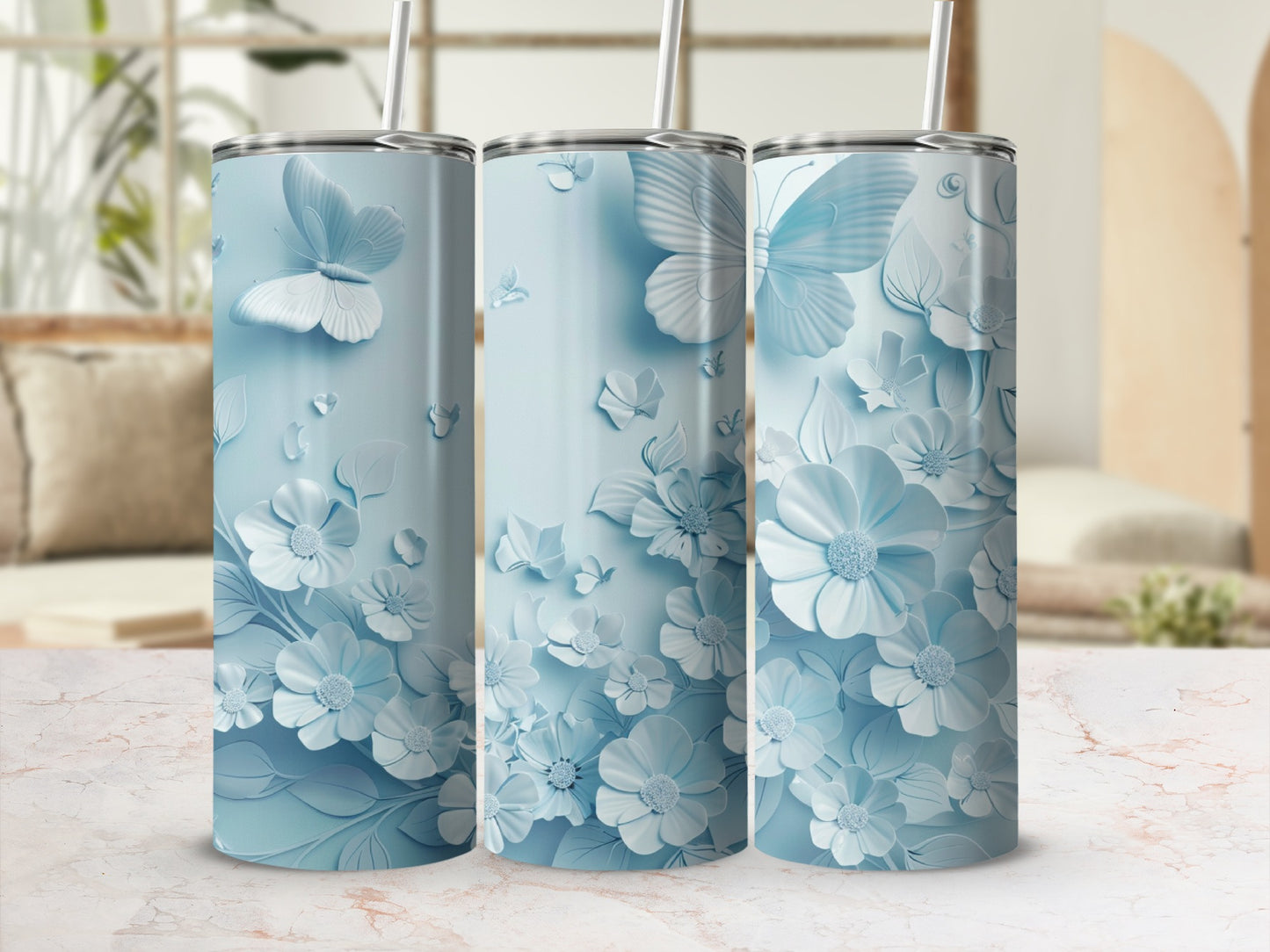 Three light blue tumblers with butterfly and floral embossed designs.