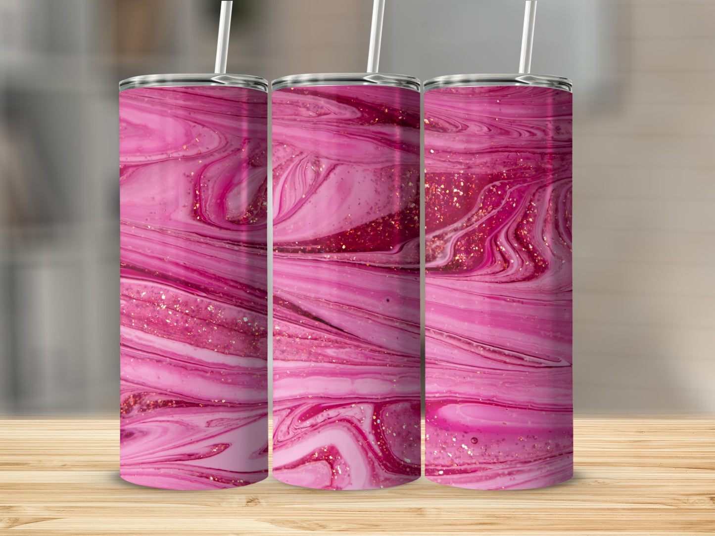 Three pink marble design tumblers with glitter on a wooden surface.