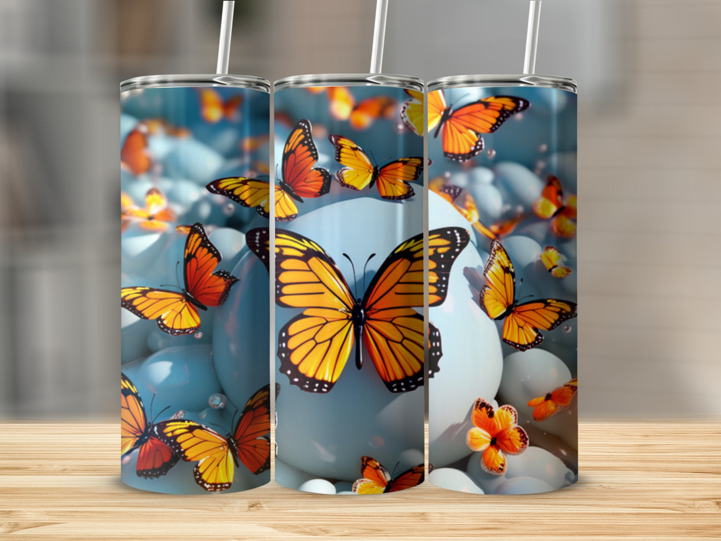 Three tumblers with colorful butterflies and blue spheres.