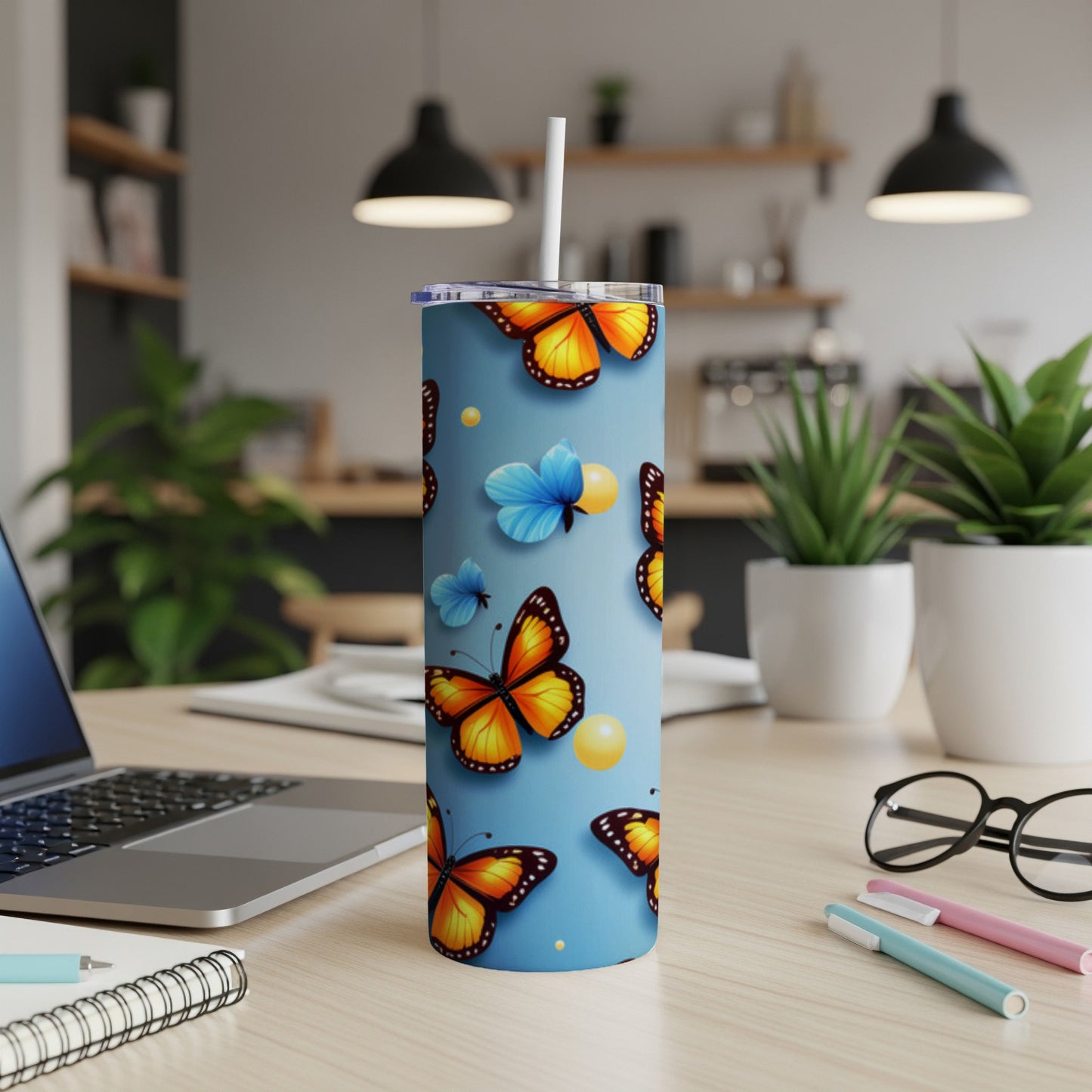 Blue tumbler with orange butterflies and yellow orbs.