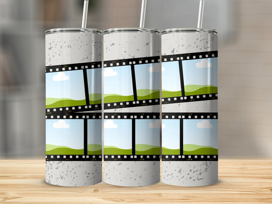 Three tumblers with speckled gray design and film strip frames of green hills and sky.