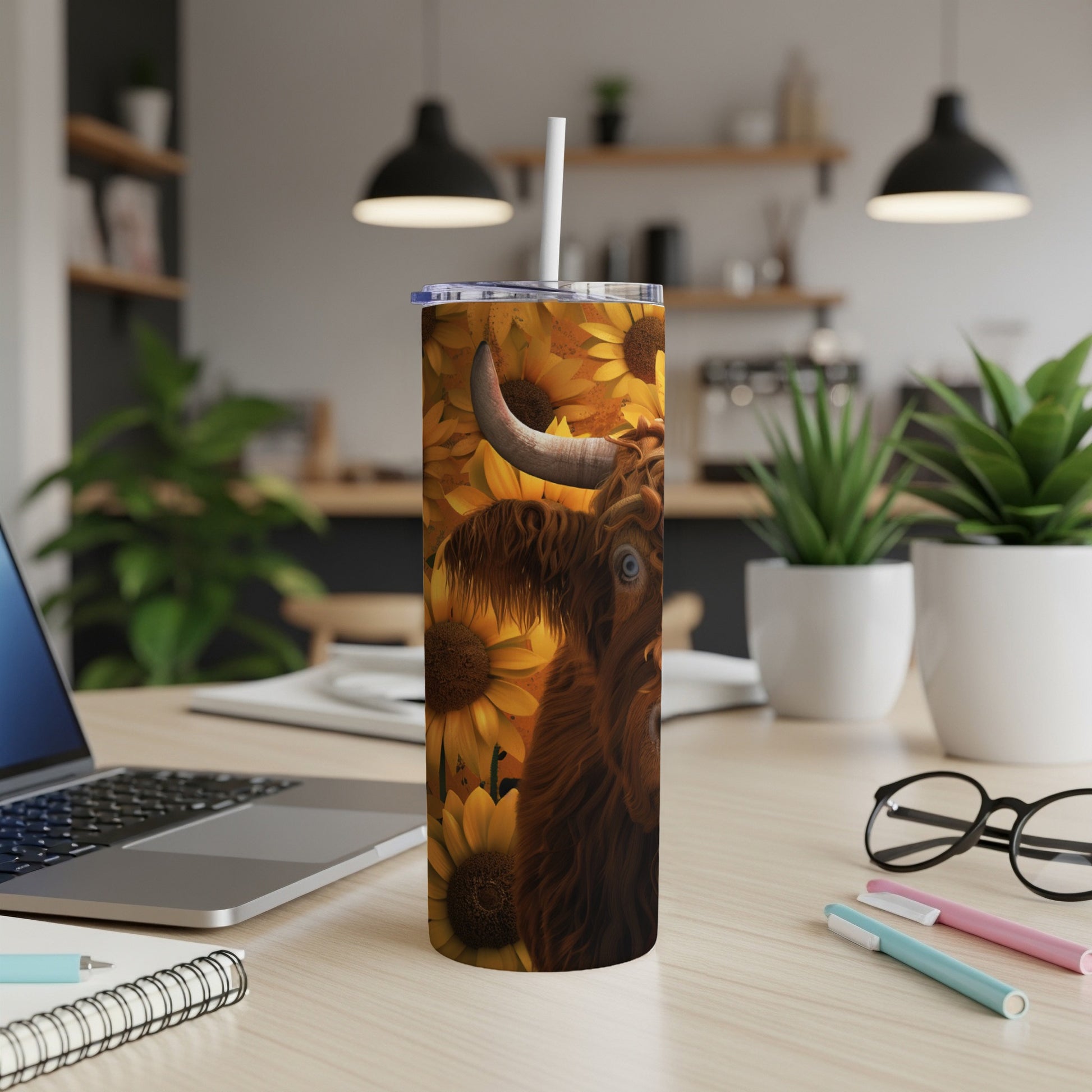 Highland cow illustration on a sunflower-patterned tumbler with a straw.