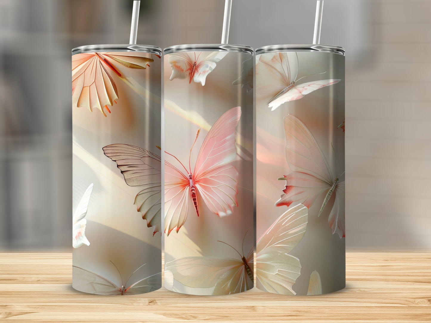 Three tumblers with pastel butterfly designs on a wooden surface.