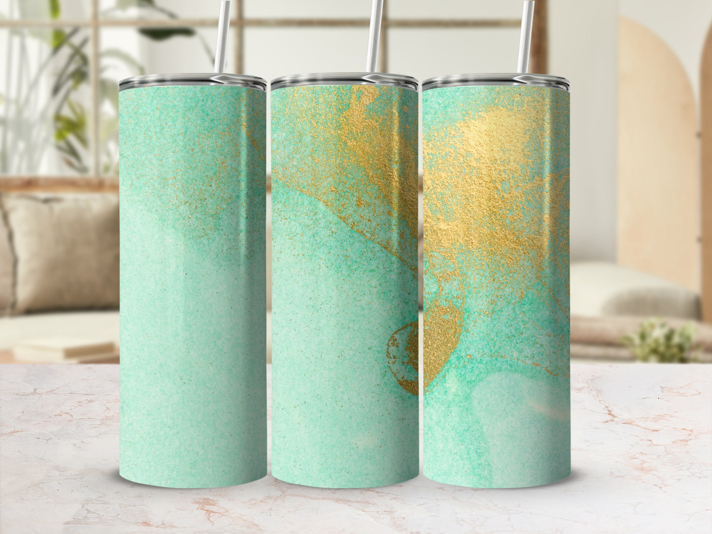 Three teal and gold abstract pattern tumblers with straws.