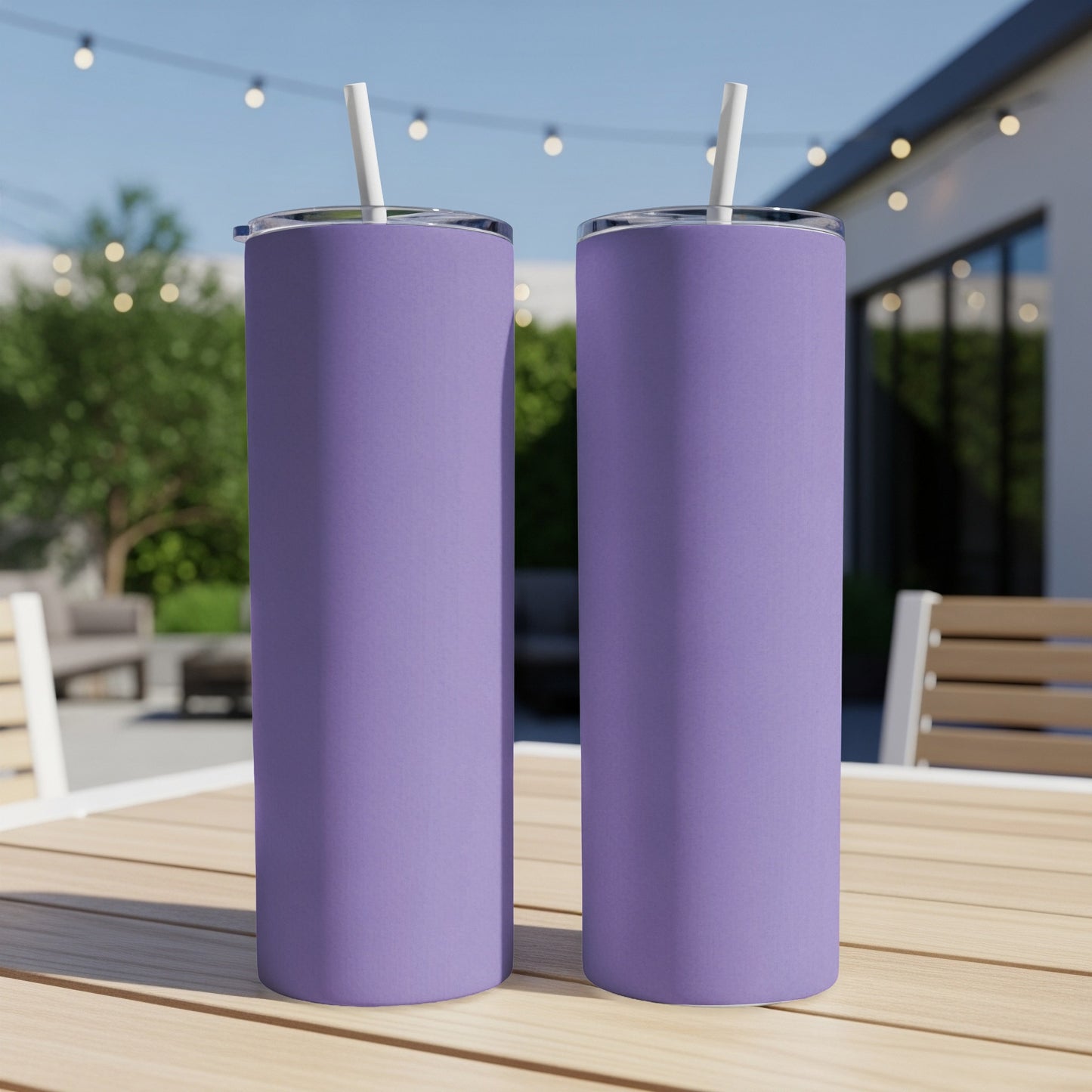 Two tall, purple tumblers with white straws on a wooden table outdoors.