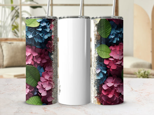 Three tumblers with floral designs and glitter accents on a marbled surface.