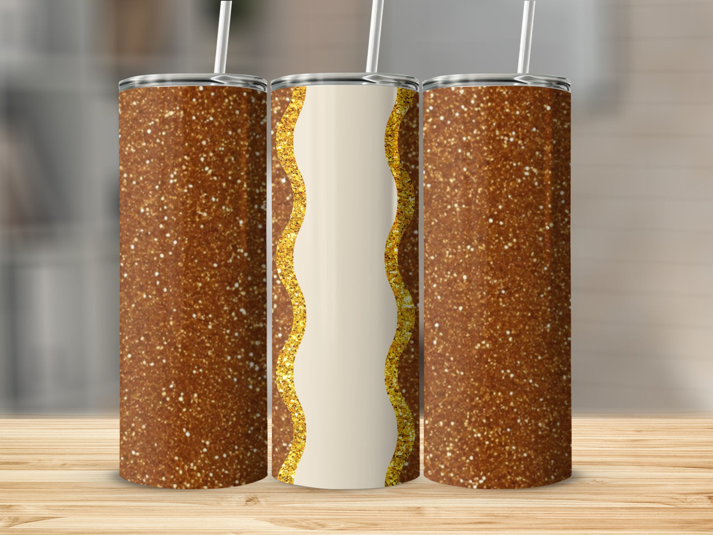 Three glitter tumblers with a golden wavy design on the center one.