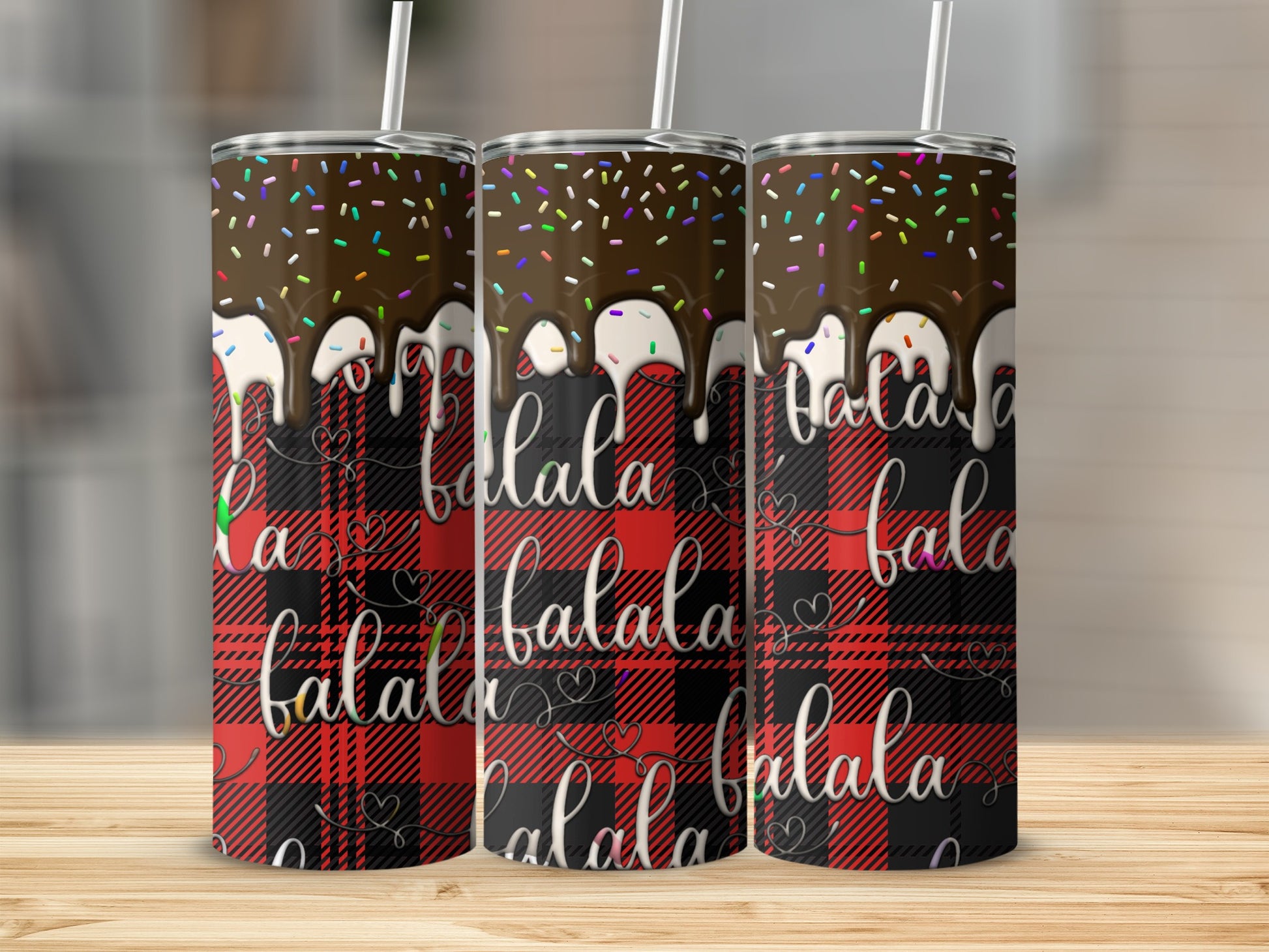 Three tumblers with chocolate drizzle, sprinkles, and "falala" text on plaid background.