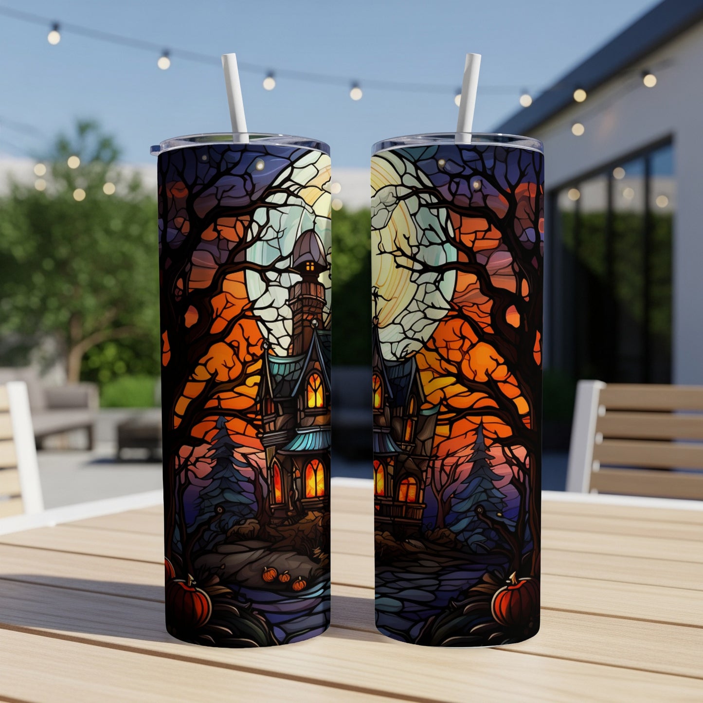 Two tall tumblers featuring a spooky Halloween scene with a haunted house and jack-o'-lanterns.