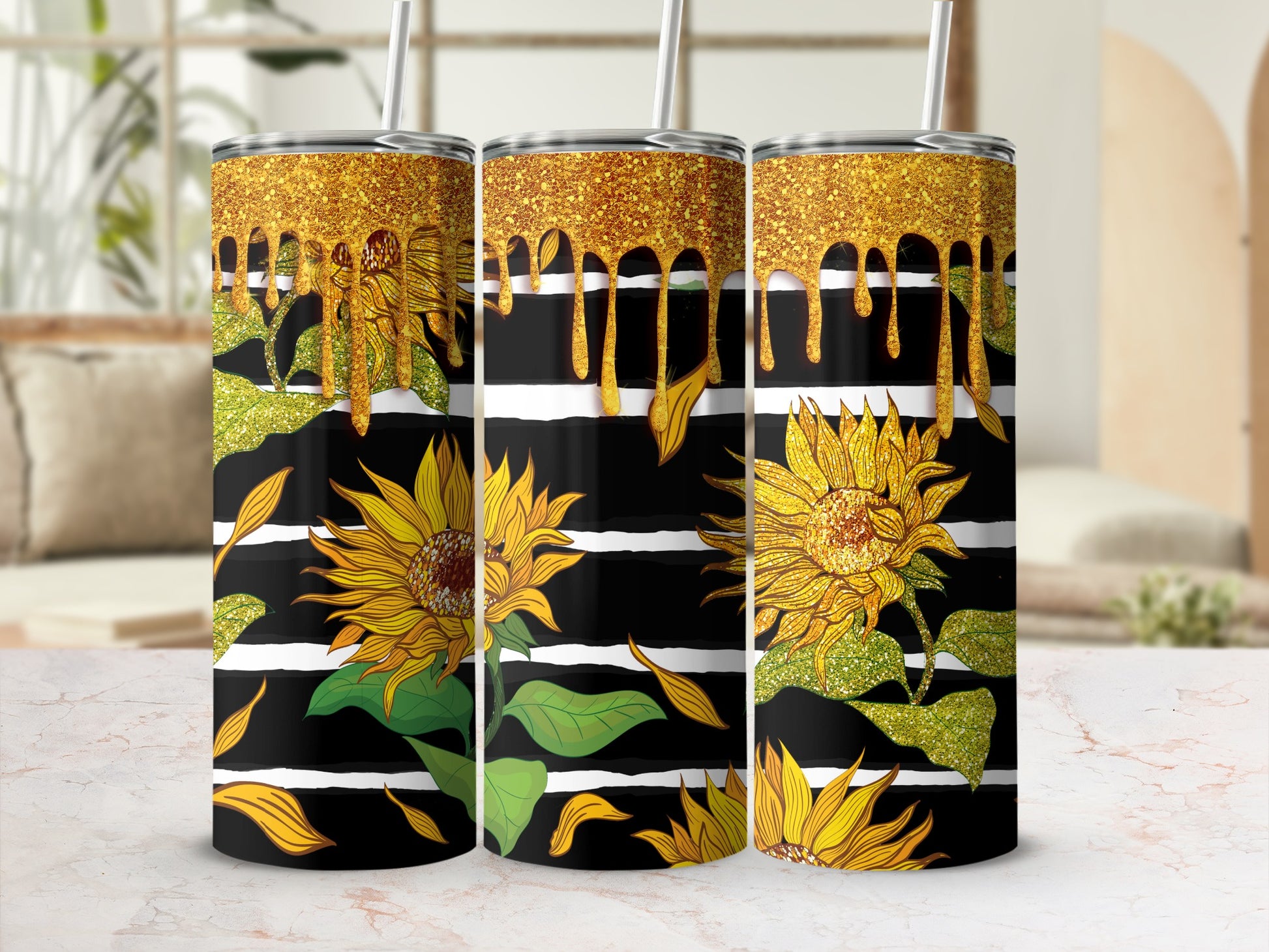 Three tumblers with sunflowers and gold glitter drips on black and white stripes.