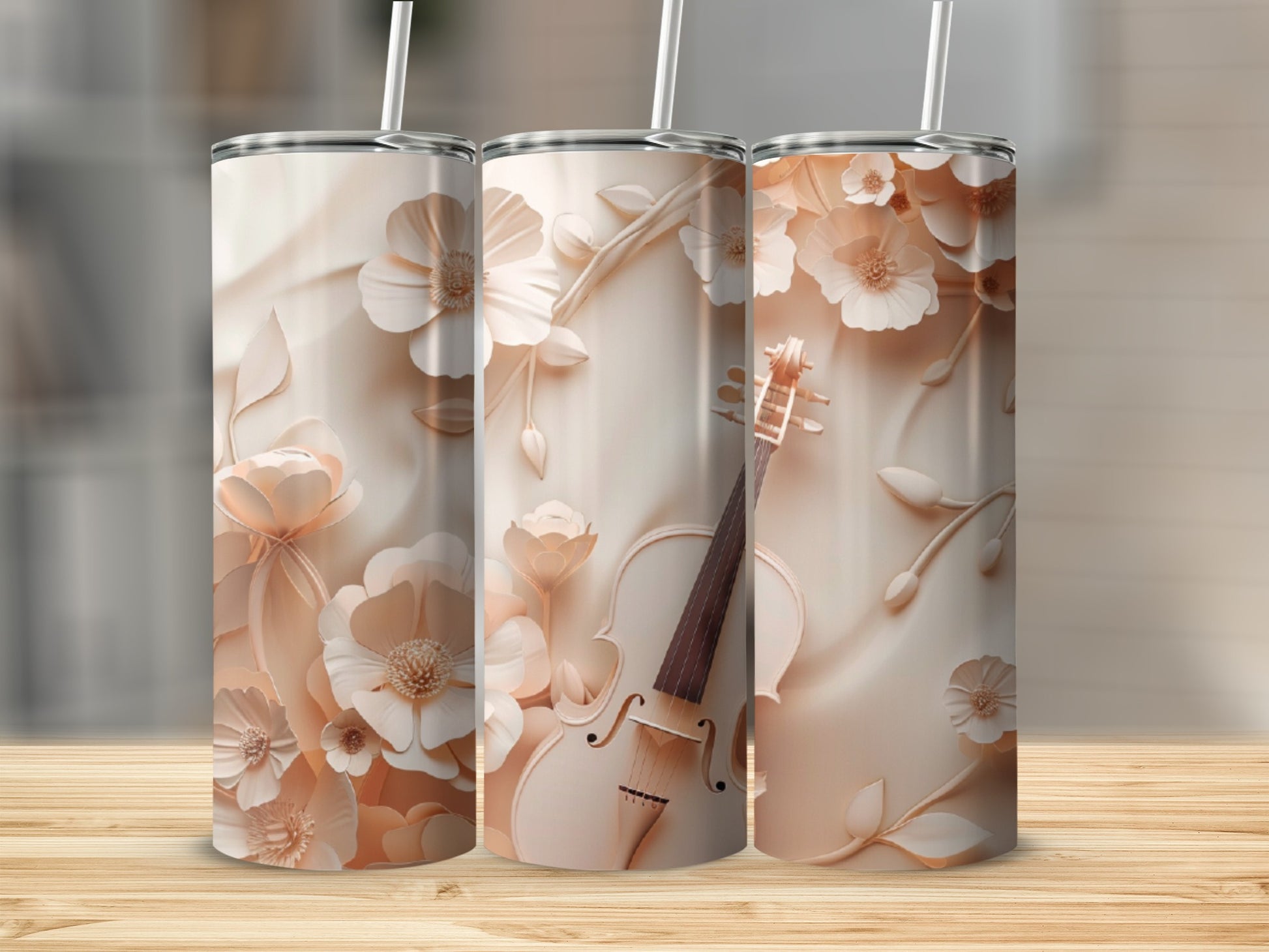 Three floral-patterned tumblers with a violin design on a wooden surface.