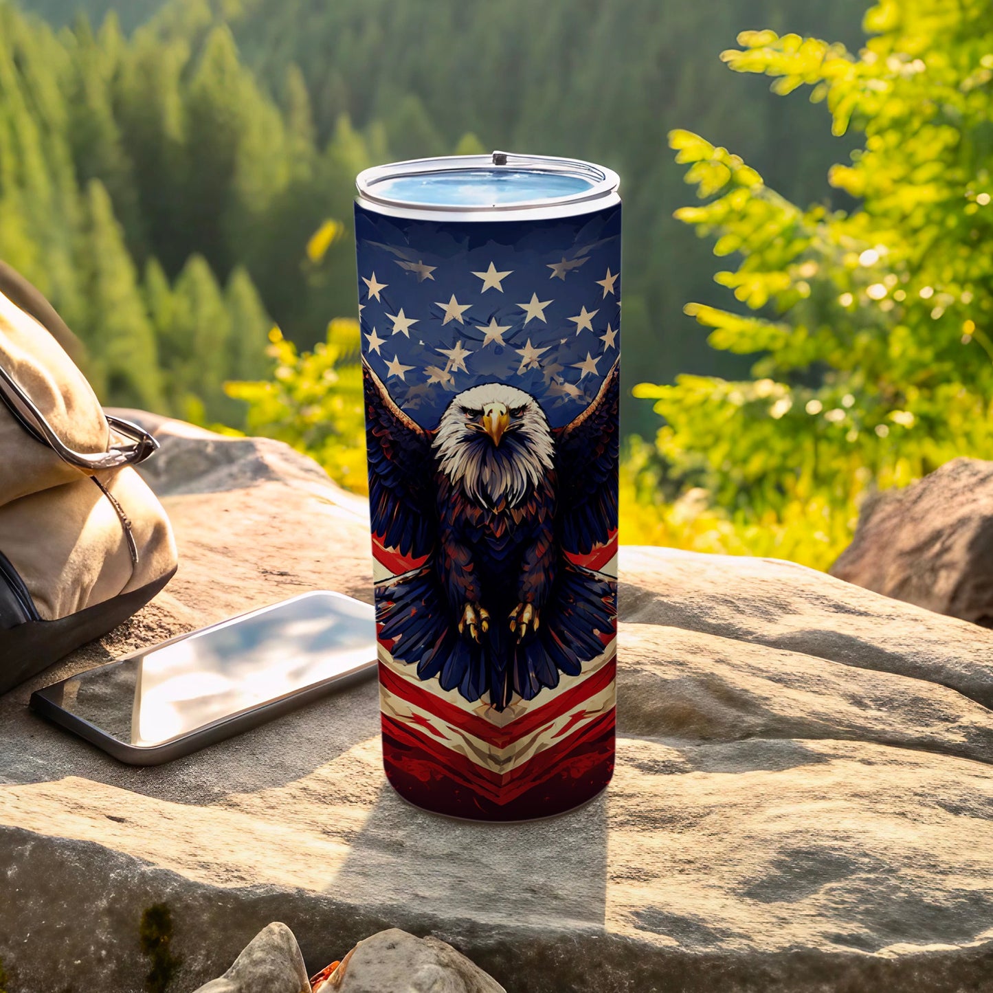 American flag eagle design on a tumbler with phone and backpack outdoors.