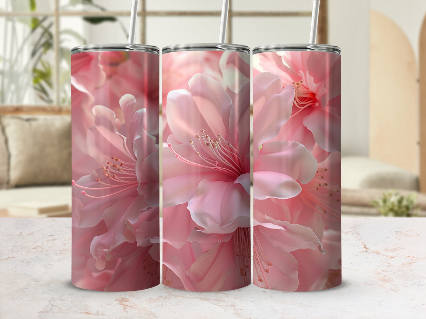 Three pink floral patterned tumblers with straws, in a bright, soft-focus setting.