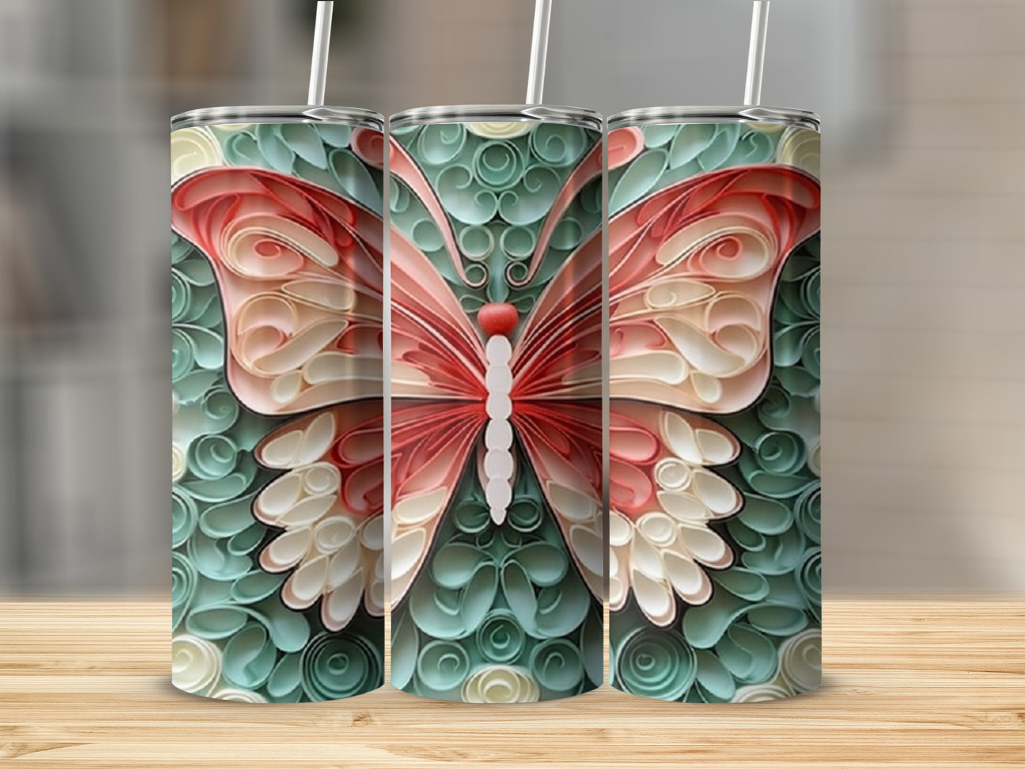 Three tumblers with a pink and cream butterfly design on a teal background.