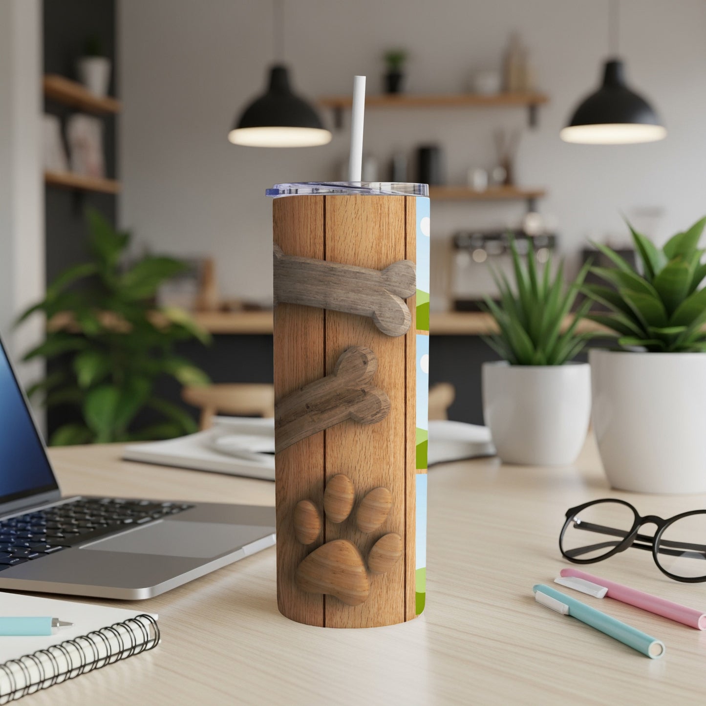 Wooden tumbler with a dog paw print and bones design, featuring a straw.