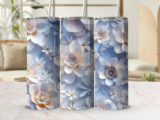 Three floral patterned tumblers with straws against a blurred background.