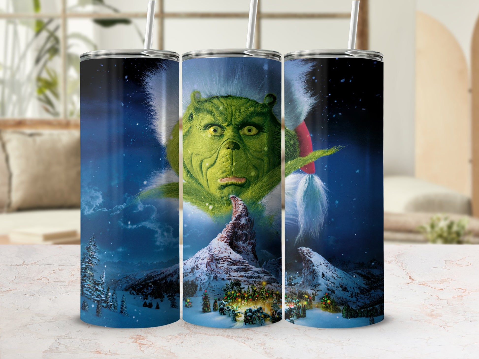 The Grinch is shown with a winter village scene and snowy mountains.