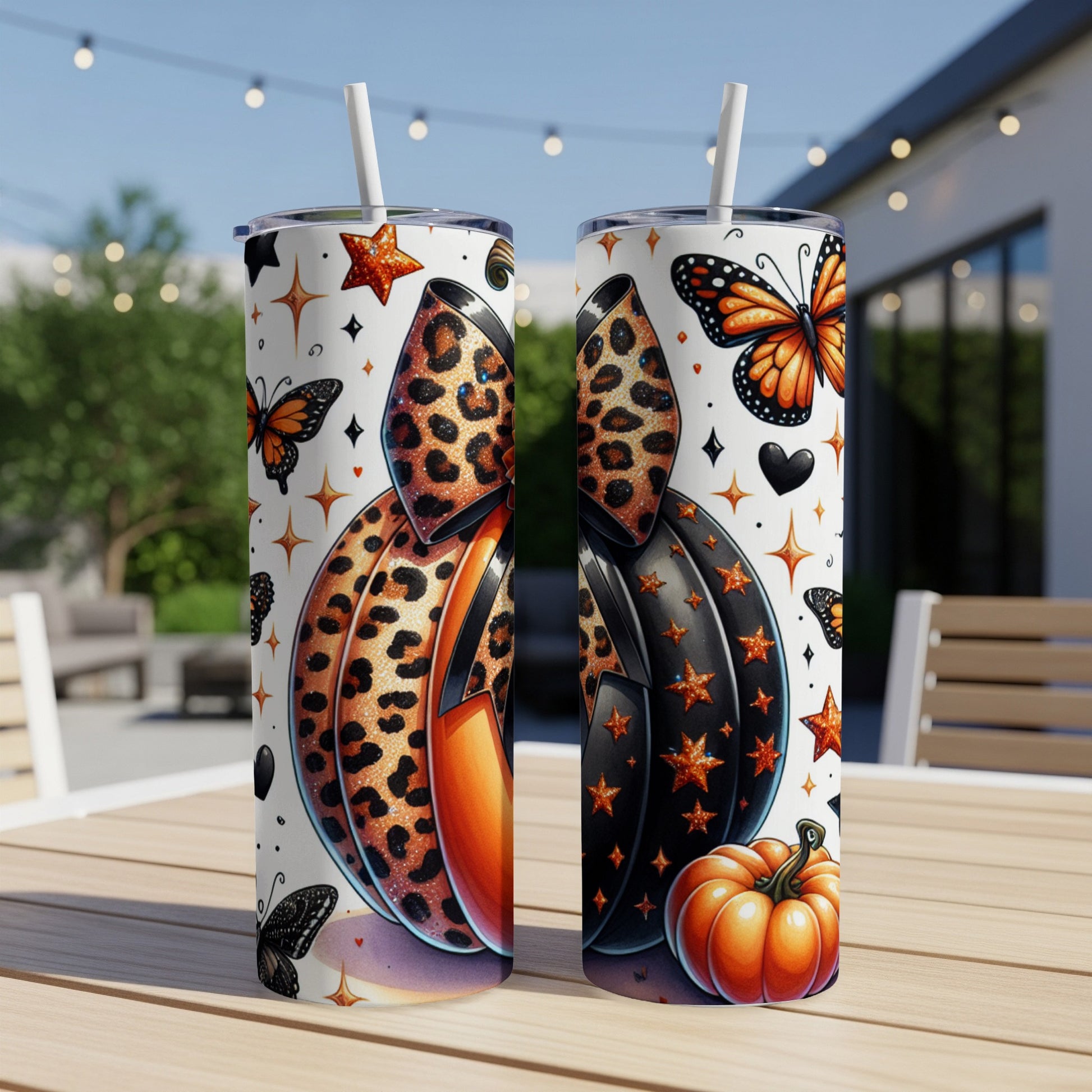 Two tumblers with Halloween pumpkin and butterfly designs.
