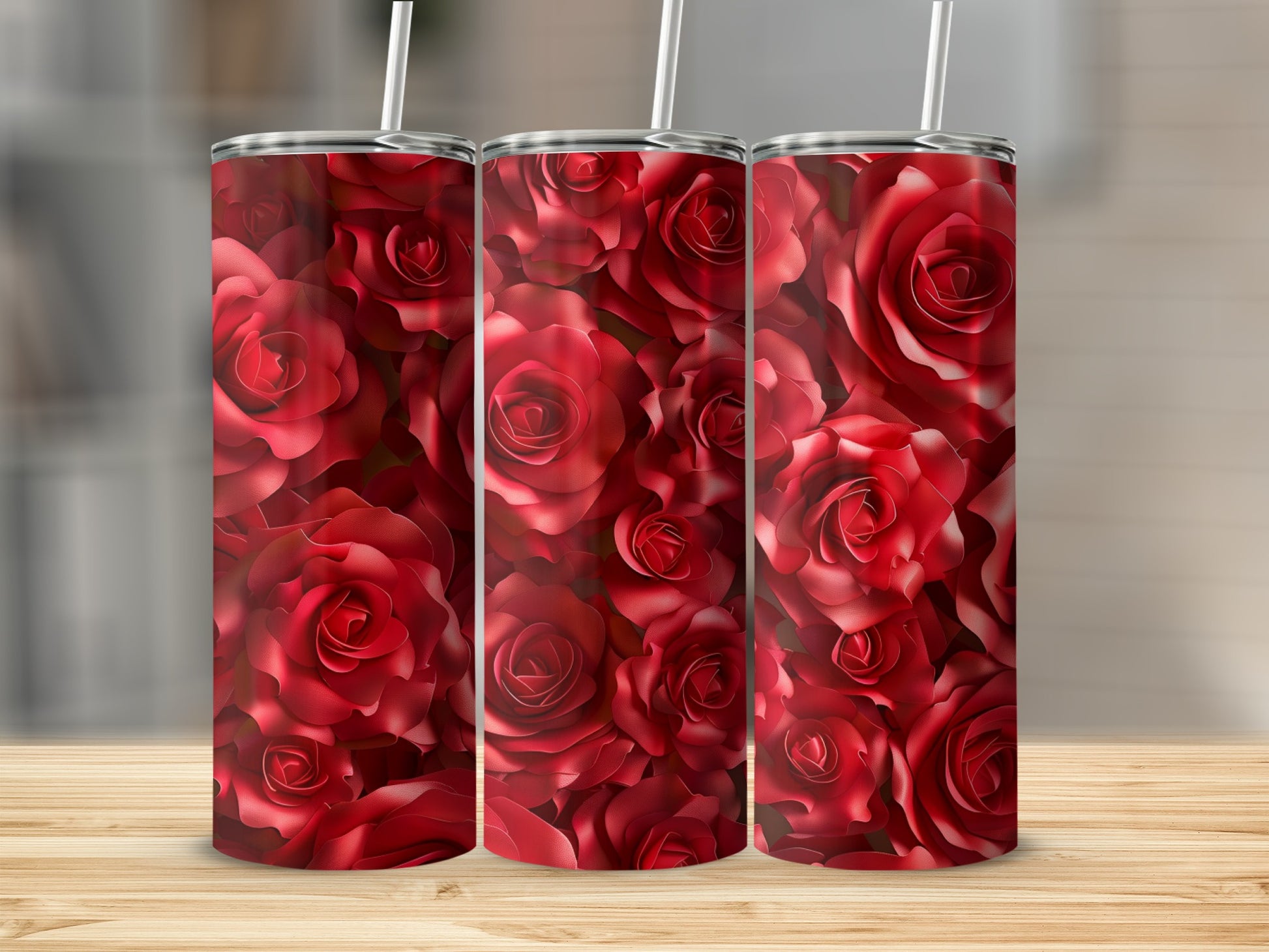 Three tumblers with a repeating pattern of red roses on a wooden surface.